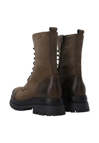 Hnědé kožené kotníkové boty s tkaničkami, bočním zipem a robustní černou gumovou podrážkou. Hladký povrch s matným finišem.