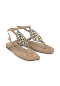 Beige suède sandalen met een platte zool en bandontwerp. Decoratieve deze in verschillende maten versieren het voorpaneel. Vierkante neusvorm.