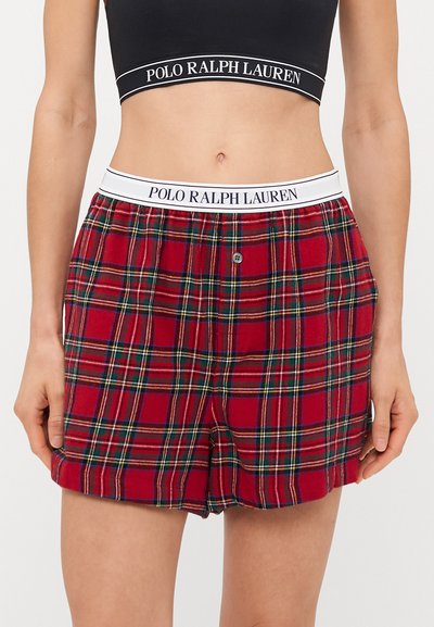 Raudoni languoti šortai, pagaminti iš minkštos medžiagos, su balta elastinga juosta, užrašyta "POLO RALPH LAUREN", ir vienu mygtuku užsegami.