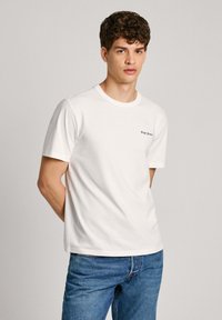 Balta medvilnė t-shirt su trumpomis rankovėmis ir apvaliu kaklu, su mažu juodu "Pepe Jeans" logotipu priekyje. Laisvas kirpimas.