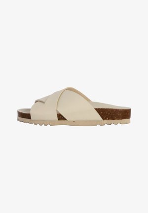 Sandalia deslizante beige con tiras cruzadas, plantilla de corcho y suela de goma texturizada. Diseño minimalista con forma plana y bordes redondeados.