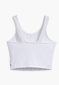 Débardeur blanc raccourci avec de larges bretelles, fabriqué en coton doux. Présente un design simple et une construction sans coutures sur les bords.