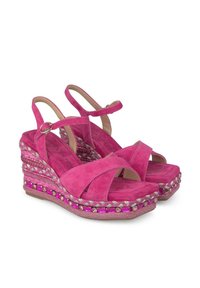 Sandales compensées en suède rose avec un design à brides croisées, des accents perlés et un talon tissé à motifs. Comprend une bride de cheville sécurisée.