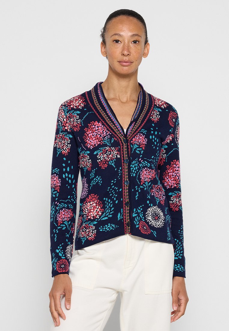 Cardigan navy con motivi floreali in rosa, bianco e teal. Presenta un colletto sciallato, chiusura con bottoni e un tessuto lavorato a maglia.