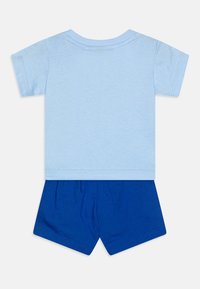 Camiseta de algodón azul claro con mangas cortas, combinada con pantalones cortos de algodón azules. Diseño simple con cuello redondo y cinturilla elástica.
