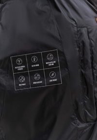 Zwarte jasinterieur met een label waarop iconen zijn afgebeeld die gerecycled dons, warmte, waterafstotendheid (4000 mm), ademend vermogen, windbestendigheid en lichtgewicht benadrukken.