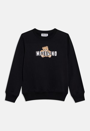 Bluză neagră cu mâneci lungi, cu manșete și tiv striate, având pe piept un ursuleț ținând litere albe în bloc care formează cuvântul „MOSCHINO”.