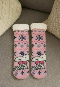 Pink cozy socks with a fluffy white cuff, featuring a snowflake pattern and cartoon characters in black and white at the toe.