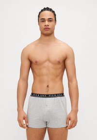 Graue Baumwoll-Boxershorts mit einem schwarzen Bund, auf dem "PIER ONE" in Weiß steht. Gerade geschnittenes Design, weicher Textur und minimale Details.