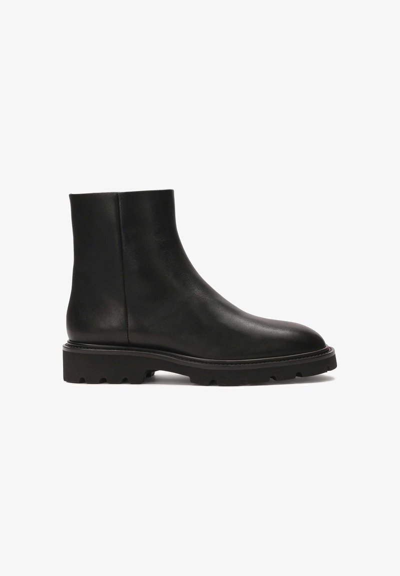 Black leather ankle boot with a rounded toe and chunky rubber sole. Smooth texture with minimal stitching details and a sleek design.