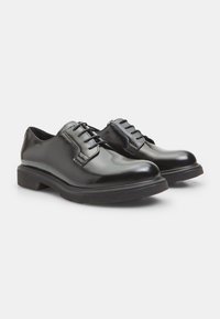 Chaussures habillées en cuir noir avec une finition lisse, un bout rond et un design à lacets. Elles disposent d'une semelle en caoutchouc légèrement surélevée.