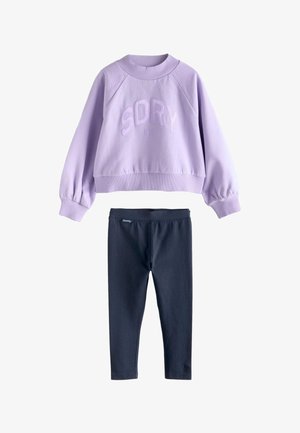 Sweat-shirt à manches longues lilas avec le texte "SDRY NYC" associé à des leggings noirs ajustés, présenté sur un fond blanc.