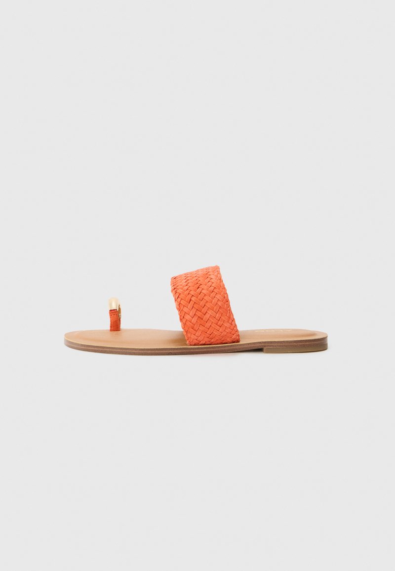 Orange woven slide sandal featuring a wide strap and a flat, tan sole with a small loop accent at the toe. Textured material throughout.
