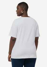 Witte t-shirt met korte mouwen, in een relaxte pasvorm en brede halslijn, gemaakt van zachte stof, met een gladde textuur en een eenvoudig ontwerp.