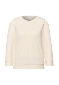 Jasnobeżowa bluza z okrągłym dekoltem, rękawami o długości do połowy przedramienia i gładką, miękką fakturą. Mankiety i dół wykończone prążkowanym ściągaczem.