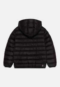 Zwarte pufferjack met capuchon, gewatteerd ontwerp, elastische manchetten en een klein logo op de linkerkant. Het materiaal lijkt glad en glanzend.