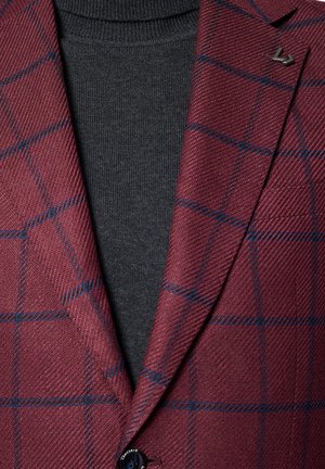 Burgundowy żakiet w kratę z teksturowanym splotem, z niebieskimi liniami, klapami i pojedynczym zapięciem na guzik na ciemnoszarym swetrze.