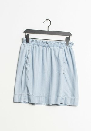 Himmelblauer, leichter Rock mit elastischem Taillenbund, seitlichen Taschen und geradem Saum. Aus weichem Stoff, hängt an einem schwarzen Haken.