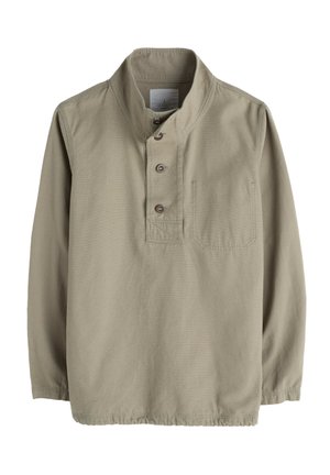 Beige langwerpige shirt met lange mouwen, gemaakt van katoen, met een opstaande kraag, knopenlijst, één borstzak en zichtbare stikseldetails.