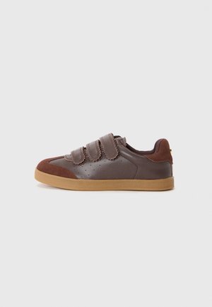 Baskets basses marron avec trois bandes velcro, côtés perforés, bout et talon en suède, semelle en gomme sur fond blanc.