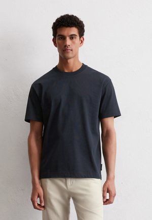 Marineblauwe katoenen t-shirt met korte mouwen, ronde hals en rechte zoom. Heeft een subtiele textuur en een klein label aan de zijkant.