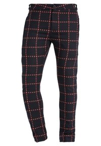 Zwarte broek met een ruitpatroon in rood en wit. Aansluitend ontwerp met een ritssluiting en knoopsluiting. Gladde textuur en elastisch materiaal.