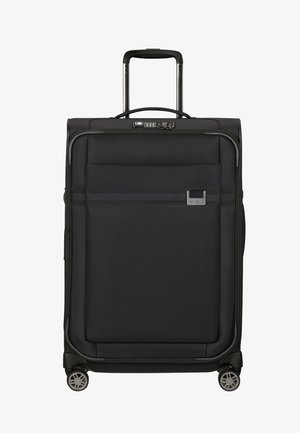 Valise noire avec un extérieur en tissu texturé, poignée latérale, poignée rétractable, poche avant et quatre roulettes pivotantes pour une meilleure mobilité.