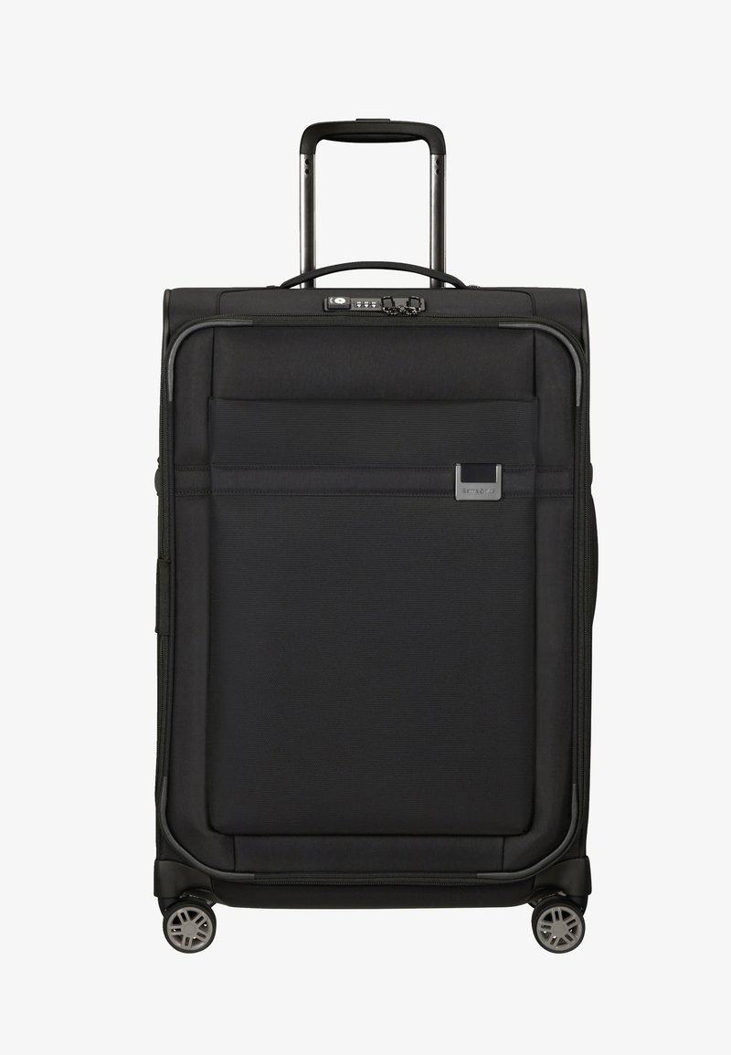 Valise noire avec un extérieur en tissu texturé, poignée latérale, poignée rétractable, poche avant et quatre roulettes pivotantes pour une meilleure mobilité.