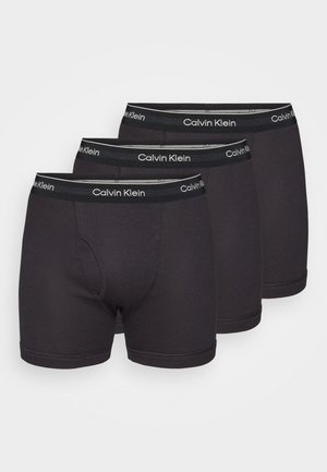 Black cotton boxer briefs, three-pack, featuring a snug fit, elastic waistbands with "Calvin Klein" logo, and smooth texture.