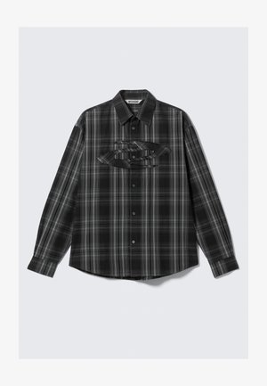 Black and gray plaid button-up shirt with long sleeves, featuring a patch pocket and unique layered design accents on the chest.