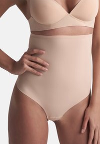 Culotte modellante beige a vita alta realizzata in tessuto morbido ed elastico, con un design senza cuciture e bordi lisci per il massimo comfort.
