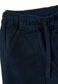 Pantalons de jogging bleu marine avec une taille élastique à texture froncée, cordon de serrage et poches latérales avec coutures plates.