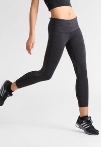 Leggings sportivi neri con un design aderente. Realizzati in materiale testurizzato, presentano una vita alta e pannelli in rete sui lati.