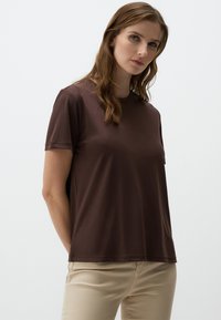 Korte mouwen bruin T-shirt, gemaakt van zachte stof, met een ronde hals en een relaxed fit. Glad textuur zonder zichtbare patronen of accenten.