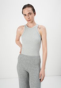 Top a righe grigio con scollo alto abbinato a pantaloni aderenti grigio chiaro coordinati. Presenta una texture liscia e un design senza cuciture.