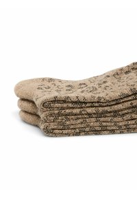 Beige sokken netjes gestapeld, met een gestructureerd breiselontwerp en zwarte patroonaccenten, evenals een lichte glans.