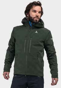 Dunkelgrüne Softshelljacke mit Kapuze, mit Reißverschlusstaschen und elastischen Bündchen. Sie verfügt über ein Logo auf der Brust und eine kontrastierende innere Schicht.