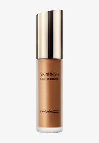 Highlighter liquide MAC Skinfinish Lightstruck dans un flacon givré avec un capuchon doré et noir brillant sur un fond blanc.