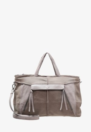 Duża torba sportowa w kolorze taupe i beżowym, wykonana z zamszu i skóry, z podwójnymi uchwytami, przednimi kieszeniami zapinanymi na zamek z frędzlami oraz odczepianym paskiem na ramię.