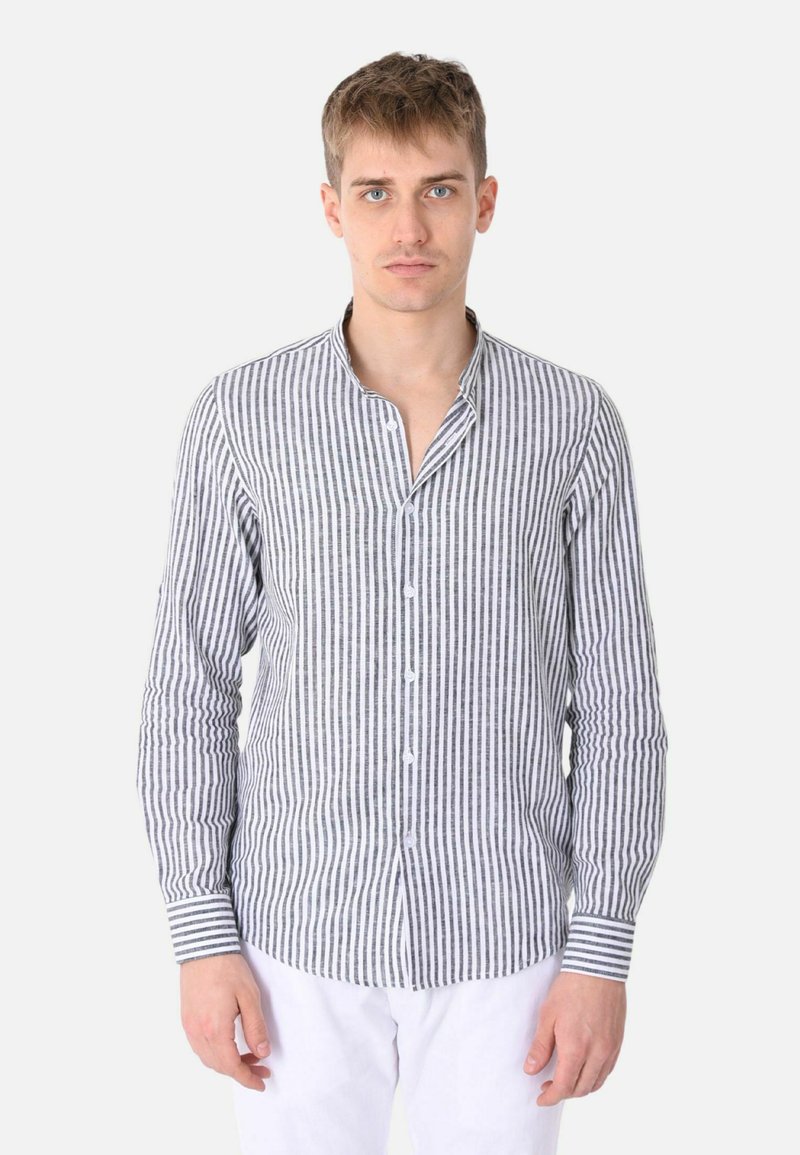 Camicia a righe nera e bianca in tessuto, con colletto alla coreana e maniche lunghe. Presenta polsini a righe contrastanti.