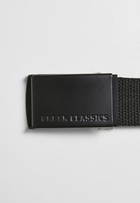 Juodas austi diržas su stačiakampiu matinio juodo metalo sagtimi. Sagtis turi įspaustą tekstą "URBAN CLASSICS" paviršiuje.