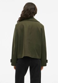 Olijfgroene cropped jacket met een brede kraag, met lange mouwen en knopenaccenten. Glad stoffenstructuur, minimalistisch ontwerp.