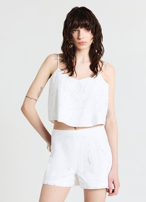 Ensemble en coton blanc composé de deux pièces comprenant un haut court à bretelles spaghetti et un short taille haute, tous deux ornés de délicates dentelles.