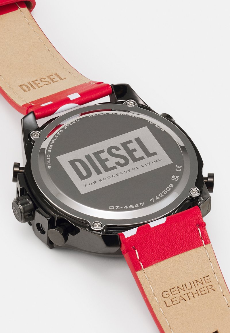 Fekete rozsdamentes acél ház "DIESEL" logóval. Piros bőrszíj fehér díszítéssel és "GENUINE LEATHER" felirattal az alsó oldalon. Vízálló.