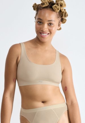 Beige nahtloser BH mit breiten Trägern und quadratischem Ausschnitt, kombiniert mit passenden Bikinihosen. Glatter, dehnbarer Stoff, minimales Design.