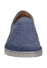 Sininen rei'itetty nahkainen luistokenkä, jossa on teksturoitu pinta, ommeltu yksityiskohtia ja vaaleanharmaa kumipohja.