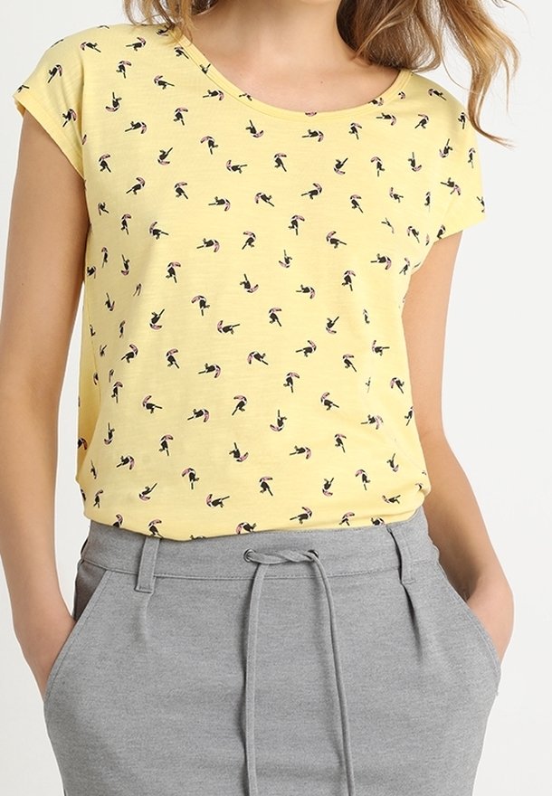 T-shirt jaune à manches courtes présentant un motif répété de petites silhouettes noires avec des accents roses. Associé à un short gris avec cordon de serrage.