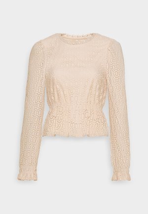 Blusa beige de manga larga de encaje con patrones circulares, escote redondo, cintura fruncida y detalles sutiles de volantes en los puños y el dobladillo.