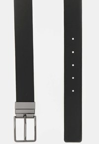Cintura nera realizzata in materiale liscio con una elegante fibbia metallica rettangolare. Presenta diversi fori per la regolazione, design minimalista.