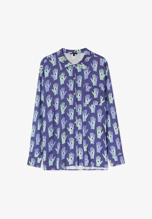 Chemise violette à manches longues avec boutons, avec un motif de mains bleues et vertes, chacune avec un œil noir dans la paume, et une petite poche poitrine.